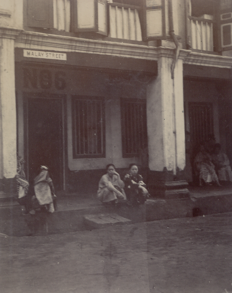 Two karayuki-san seen outside No. 6 Malay Street. Image reproduced from Sammlung von 19 originalphotographien aus Singapur (n.p.: n.p., 1880–1900). (From National Library Singapore, call no. RRARE 779.99595703 SAM).